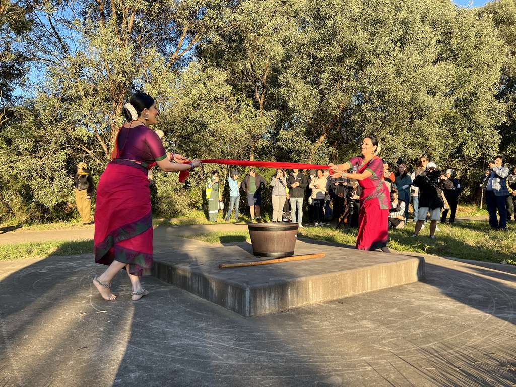 Two women wearing saris, performing as part of The River Project