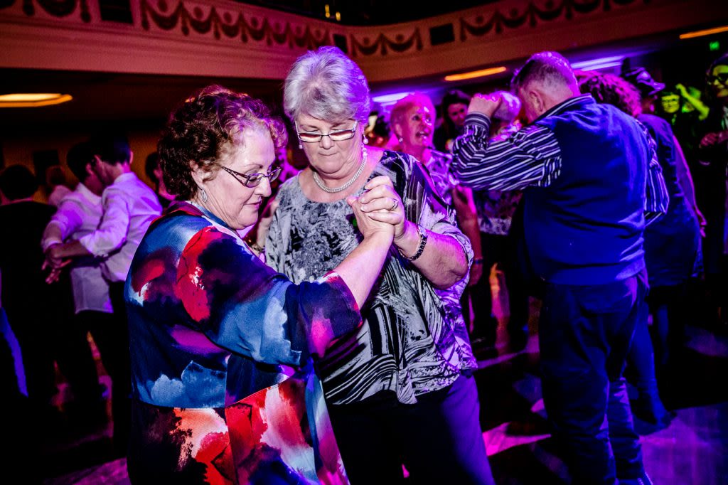 Two older women dancing together at the Coming Back Out Ball